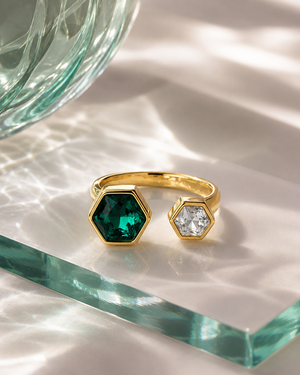 Gold open hexagon ring with green emerald-cut stone and white clear hexagon stone