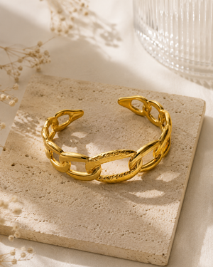 Gold sculpted link cuff bracelet with textured center bar and interlocking oval links