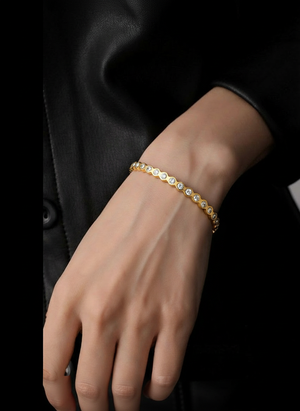 Gold tennis bracelet with small round clear crystals in a straight row