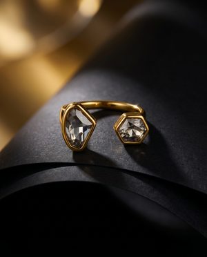Gold ring with geometric gemstones on a dark surface