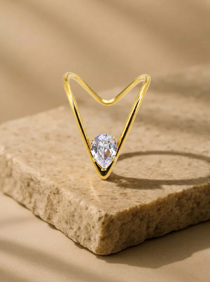 Gold open V ring with round clear gemstone on stone block