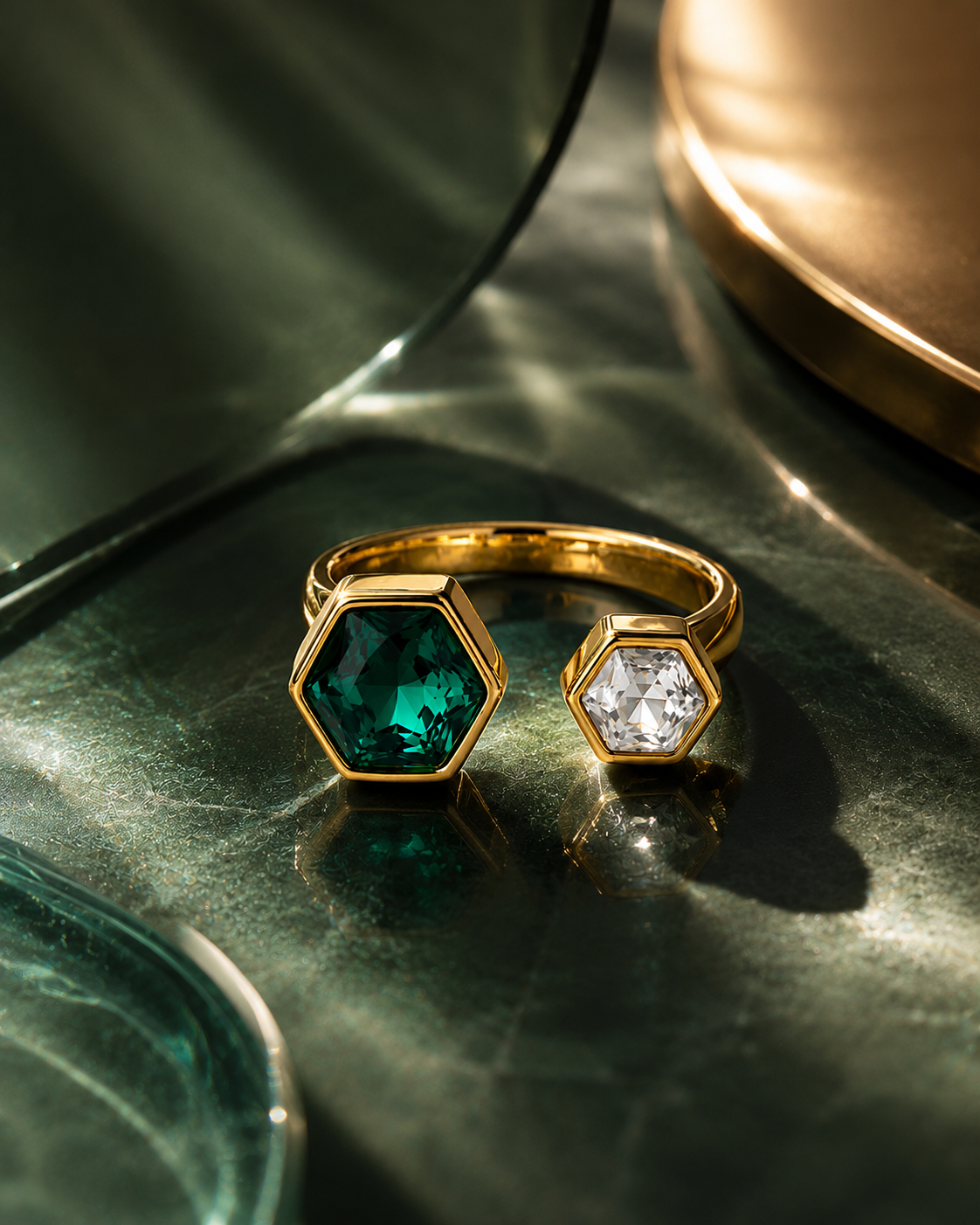 Gold open hexagon ring with dark green hexagon gemstone and clear hexagon gemstone