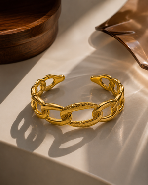 Gold sculpted link cuff bracelet with interlocking oval links and textured segments