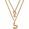 Gold-tone layered snake charm necklace with knot-style pendant and round crystal charm