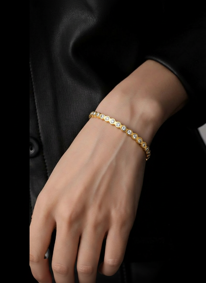 Gold tennis bracelet with small round clear crystals in a straight row