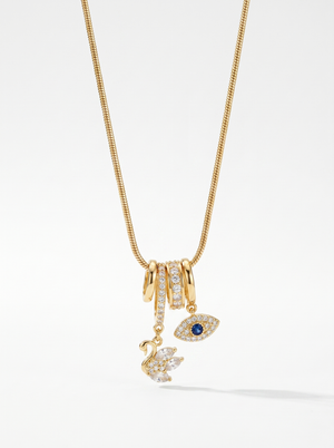 Gold charm pendant necklace with blue evil-eye enamel and small swan charms