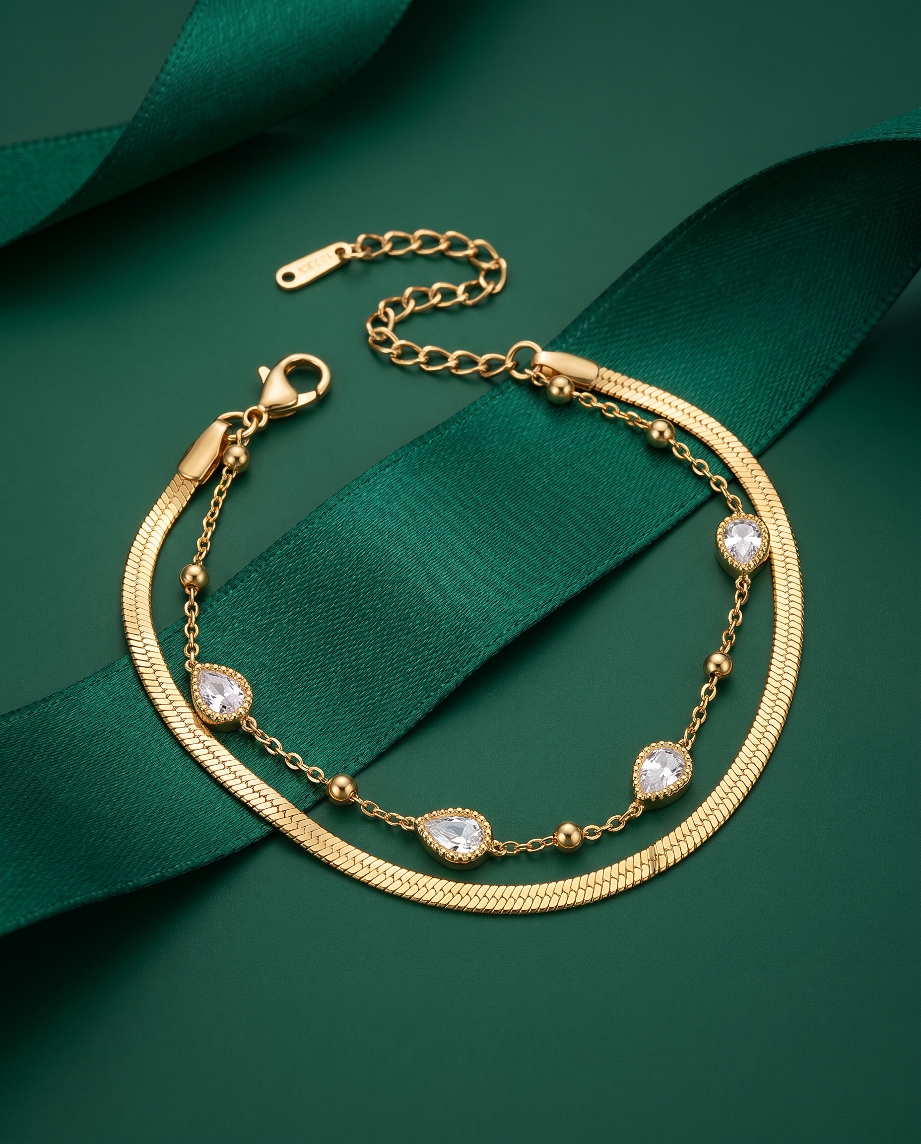 Gold layered chain bracelet with teardrop crystal charms and small toggle clasp.