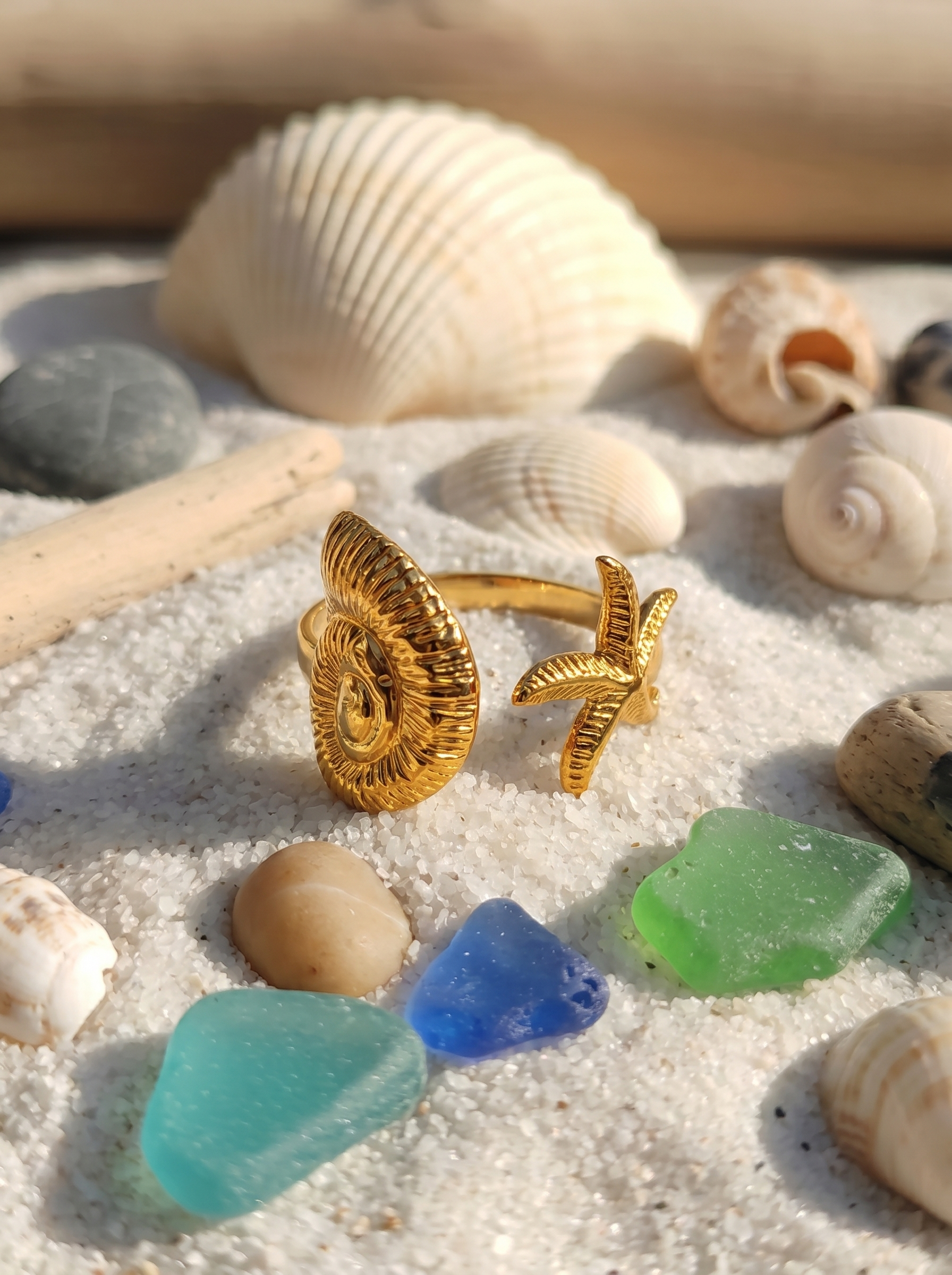 Gold-tone palm statement ring with ridged circular face and starfish charm
