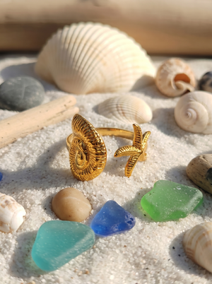 Gold-tone palm statement ring with ridged circular face and starfish charm